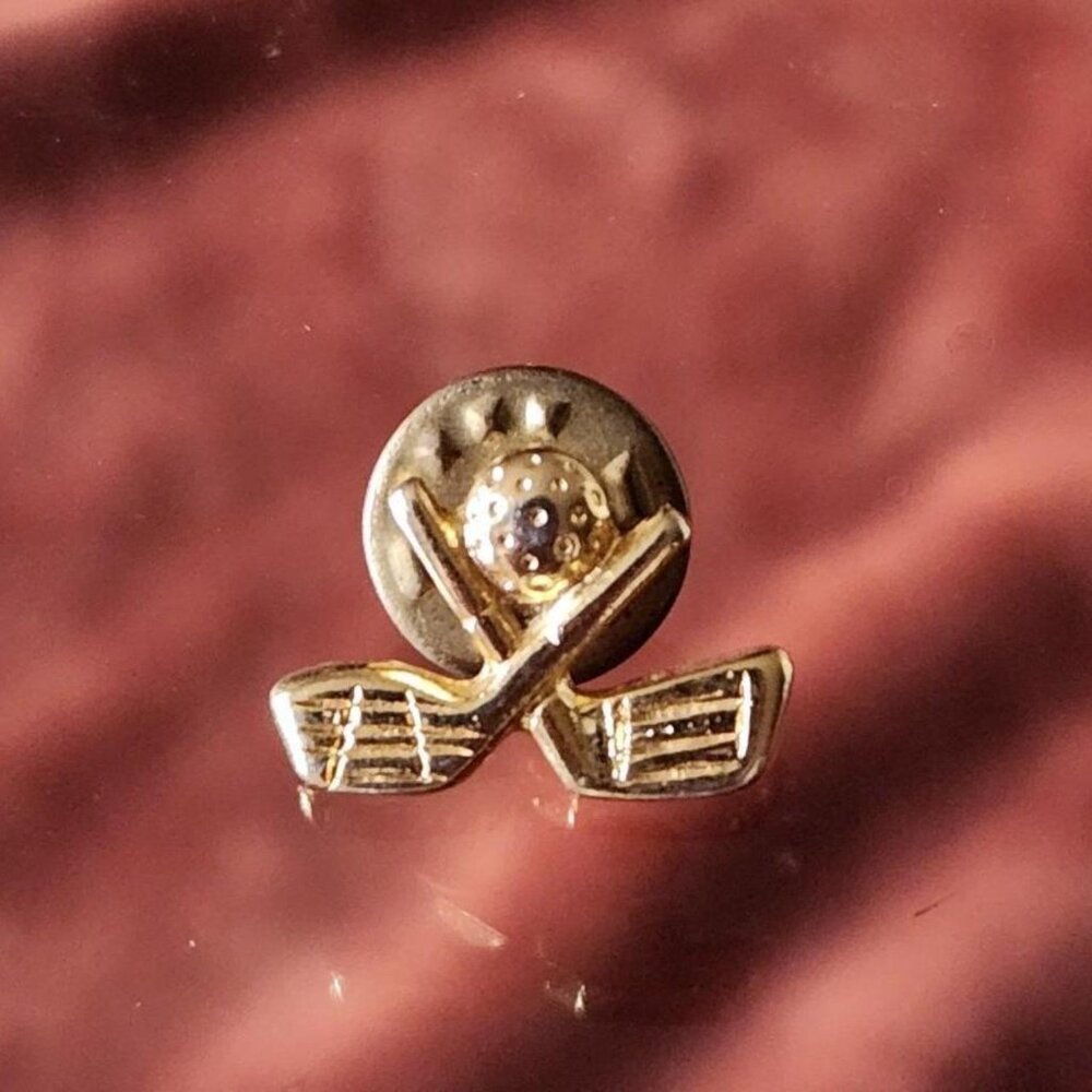 Vintage golf ball and crossed clubs lapel pin.